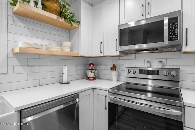 kitchen with white cabinets, light countertops, appliances with stainless steel finishes, decorative backsplash, and open shelves