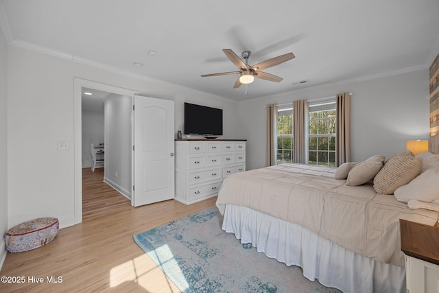 bedroom featuring ceiling fan, baseboards, light wood-style flooring, and crown molding