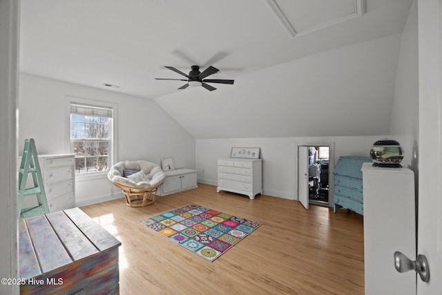 interior space with a ceiling fan, vaulted ceiling, light wood-style flooring, and baseboards