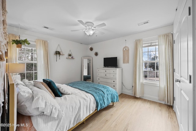 bedroom with light wood-style flooring, multiple windows, and visible vents