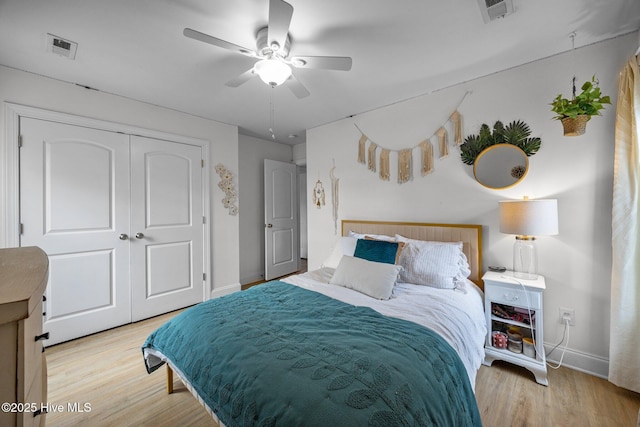 bedroom featuring baseboards, a closet, visible vents, and wood finished floors