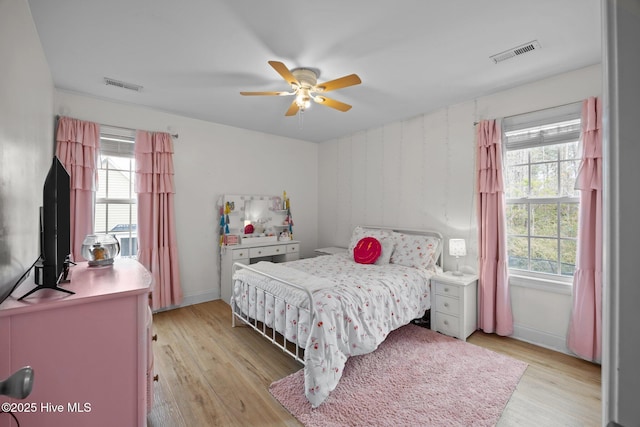 bedroom featuring visible vents, light wood finished floors, and multiple windows