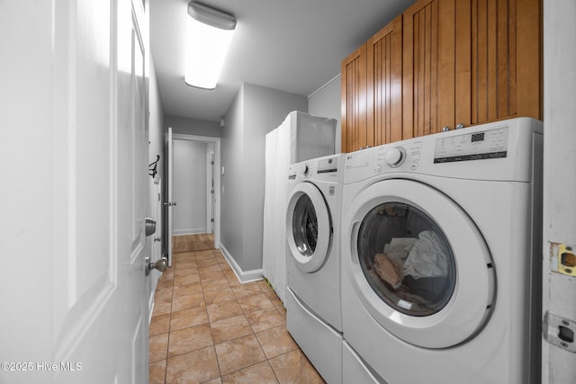 laundry room featuring cabinet space, baseboards, and independent washer and dryer