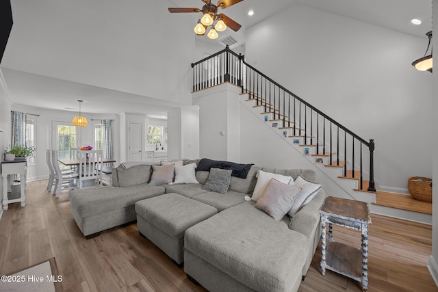 living area with stairs, recessed lighting, visible vents, and wood finished floors