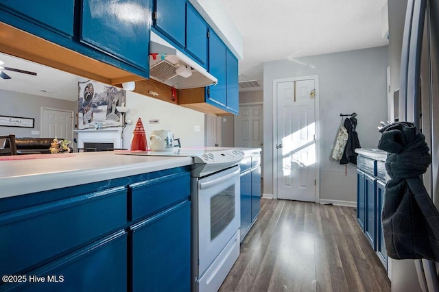 kitchen with a fireplace, a ceiling fan, blue cabinetry, dark wood-style floors, and white electric range oven