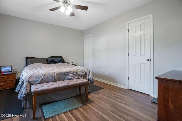 bedroom with ceiling fan, a textured ceiling, baseboards, and wood finished floors