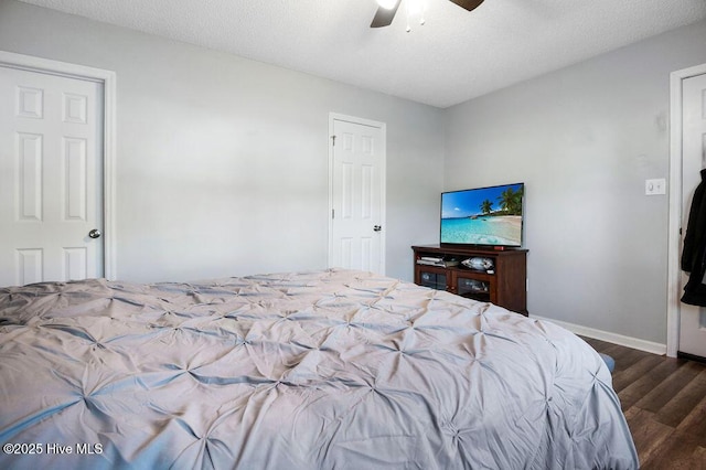 bedroom featuring ceiling fan, a textured ceiling, baseboards, and wood finished floors