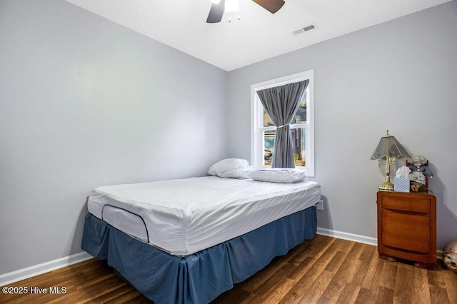 bedroom featuring wood finished floors, visible vents, and baseboards