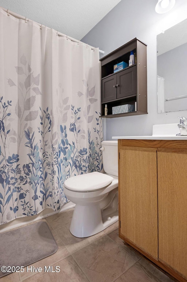 full bathroom with a textured ceiling, vanity, toilet, and a shower with curtain