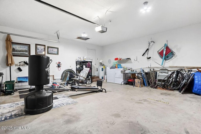 garage featuring washing machine and dryer, electric water heater, and a garage door opener