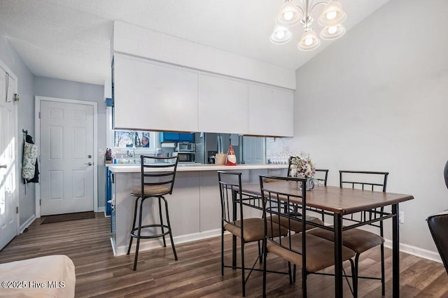 dining area with vaulted ceiling, dark wood-style flooring, baseboards, and an inviting chandelier