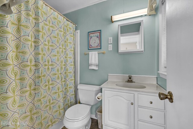 full bathroom featuring curtained shower, vanity, and toilet