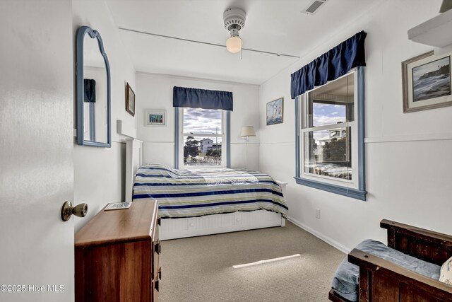 carpeted bedroom featuring ceiling fan, visible vents, and baseboards