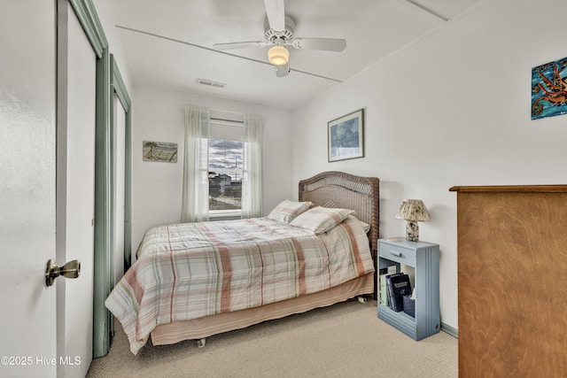 carpeted bedroom featuring visible vents and a ceiling fan