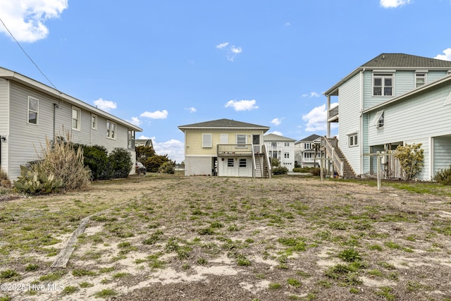 back of property featuring a residential view, a wooden deck, and stairs