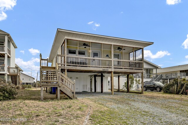 rear view of house featuring a ceiling fan, stairs, driveway, a carport, and board and batten siding