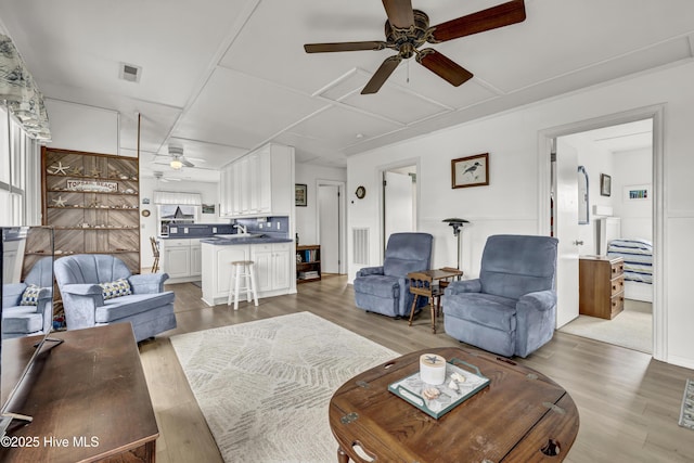 living room featuring light wood-style floors, ceiling fan, and visible vents