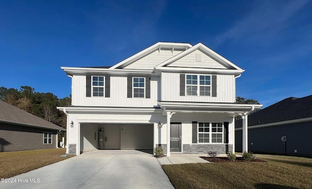 view of front facade featuring an attached garage, driveway, stone siding, board and batten siding, and a front yard