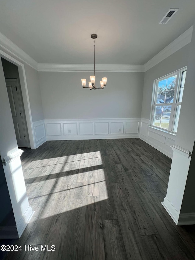 unfurnished dining area with dark wood-style floors, a wainscoted wall, visible vents, an inviting chandelier, and ornamental molding