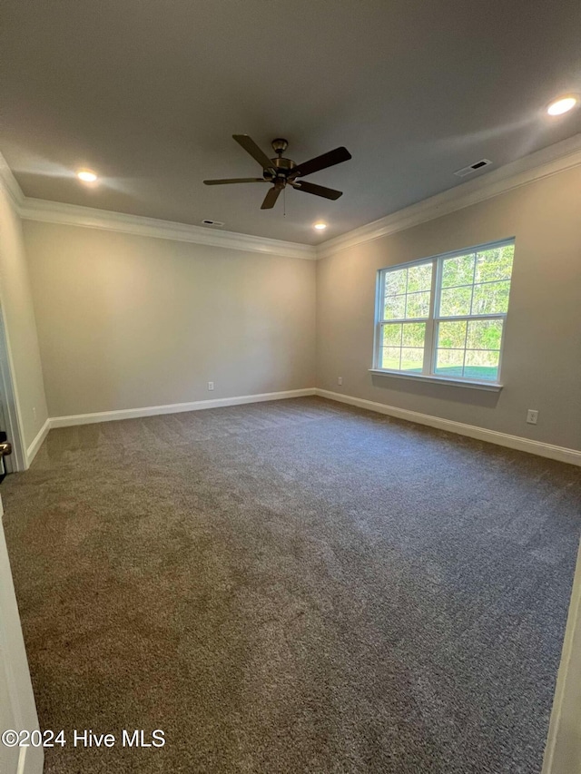 spare room with baseboards, visible vents, and crown molding