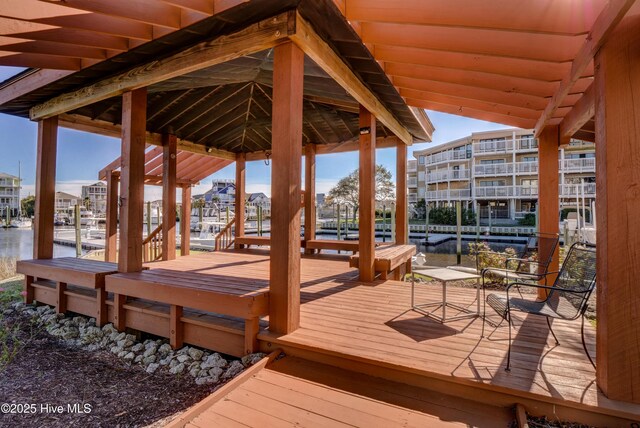 wooden deck with a boat dock and a water view