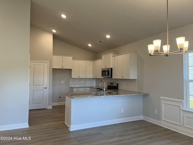 kitchen featuring dark wood-style floors, stainless steel appliances, white cabinets, light stone countertops, and a peninsula