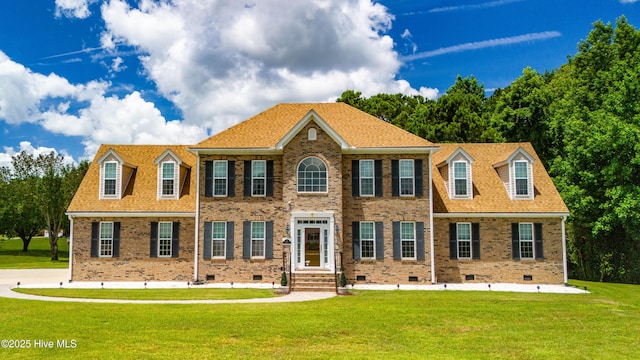 view of front of home with crawl space, brick siding, a front yard, and a shingled roof