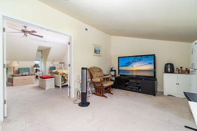 living room featuring visible vents, carpet floors, lofted ceiling, and a ceiling fan