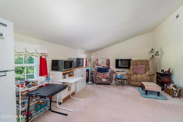 interior space featuring vaulted ceiling, light colored carpet, and visible vents