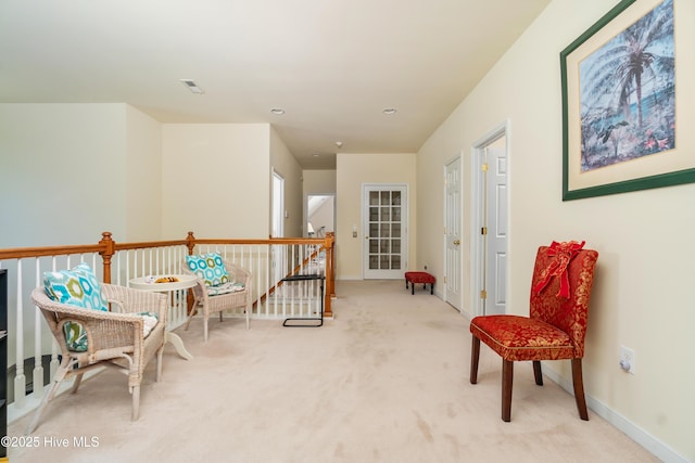 living area featuring visible vents, baseboards, an upstairs landing, and carpet flooring