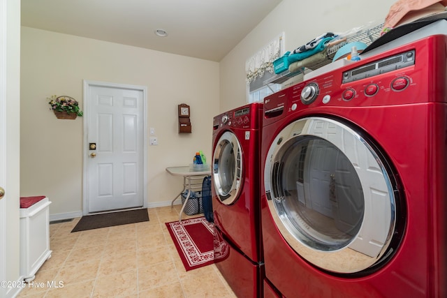 laundry room featuring tile patterned flooring, laundry area, baseboards, and washing machine and clothes dryer