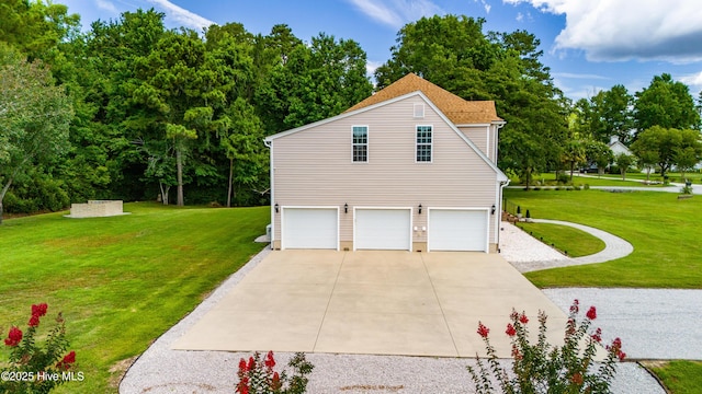 view of side of home with a yard, a garage, and driveway