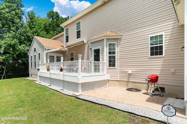 rear view of property with a yard, a deck, and a patio area