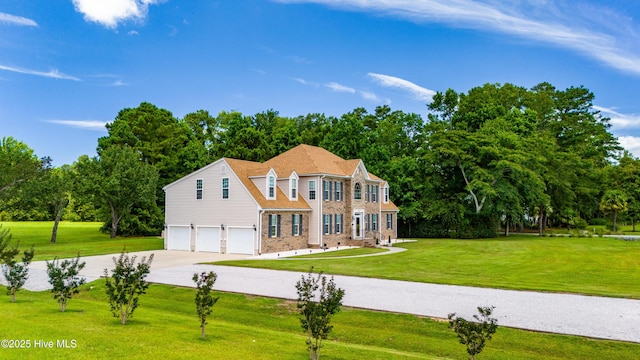 view of front of home featuring a front yard, an attached garage, brick siding, and driveway