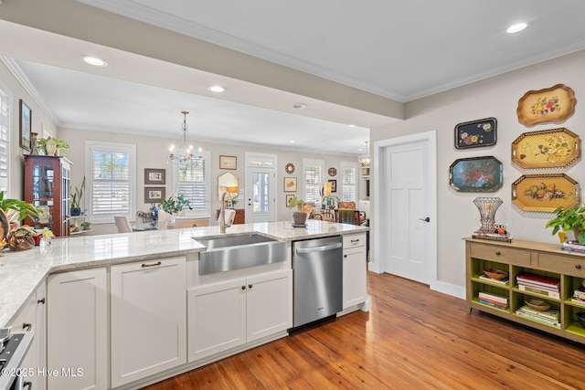 kitchen with a sink, an inviting chandelier, ornamental molding, and dishwasher
