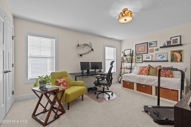 office area featuring light carpet and baseboards