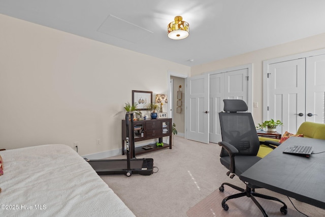 carpeted bedroom with attic access, baseboards, and two closets