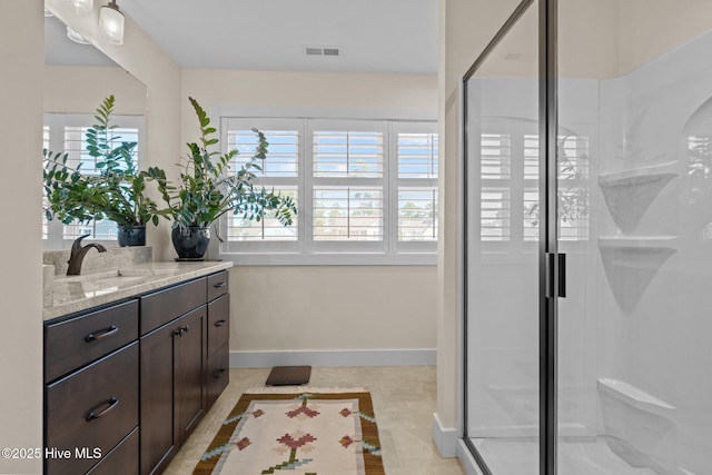 bathroom with visible vents, a shower stall, vanity, tile patterned flooring, and baseboards