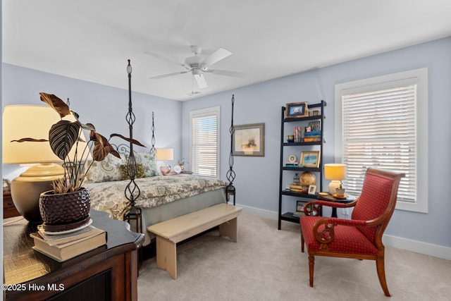 bedroom featuring a ceiling fan, light colored carpet, and baseboards