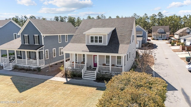 view of front of house featuring a porch, a front yard, a shingled roof, and a residential view