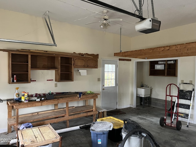 garage with baseboards, a garage door opener, and a ceiling fan