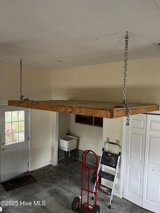 interior space featuring baseboards and a sink