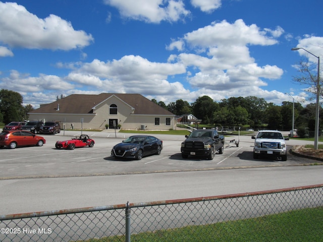 view of parking / parking lot featuring fence