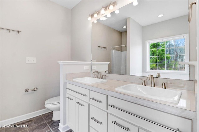 full bathroom featuring baseboards, a sink, toilet, and walk in shower