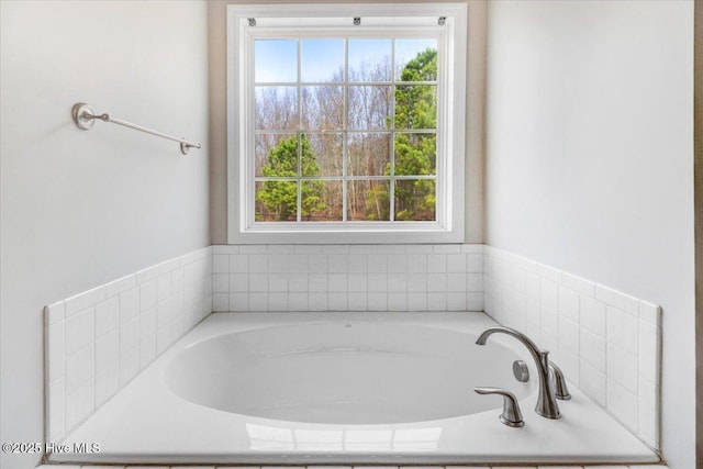 bathroom featuring plenty of natural light and a bath