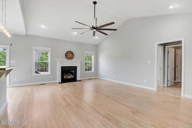 unfurnished living room featuring light wood finished floors, a fireplace with flush hearth, a ceiling fan, and baseboards