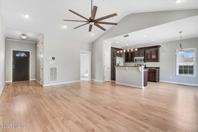 unfurnished living room featuring visible vents, ornamental molding, ceiling fan, light wood-type flooring, and baseboards