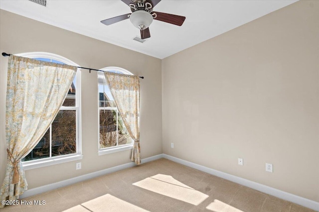 empty room featuring plenty of natural light, visible vents, baseboards, and carpet flooring