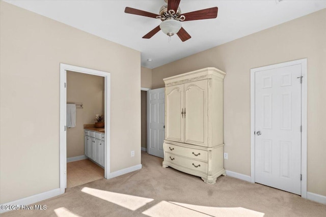 unfurnished bedroom featuring light colored carpet, ceiling fan, baseboards, and ensuite bathroom