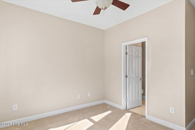 empty room featuring light carpet, baseboards, and a ceiling fan